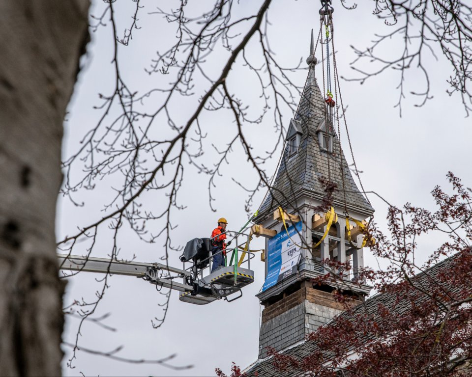 De torenspits van het Schuurkerkje wordt voorzichtig van het dak getakeld voor restauratie.